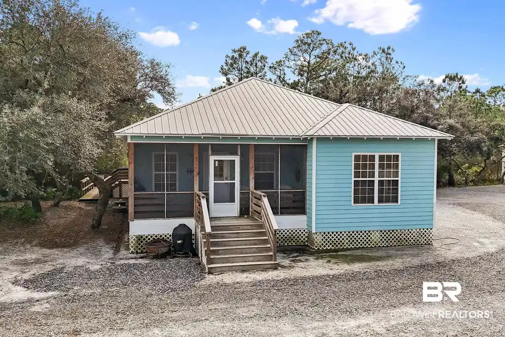 Image 1: View of front of property featuring a sunroom and a metal roof