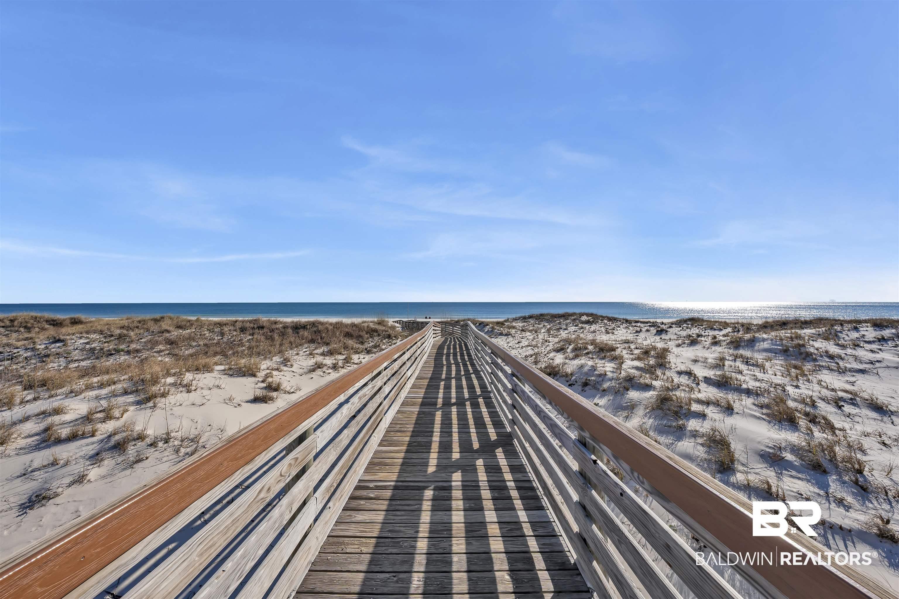 Image 3: Wooden boardwalk extending over sand dunes toward the ocean