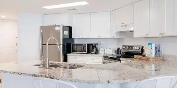 Image 3: Kitchen with white cabinetry, stainless steel appliances, a kitchen bar, and recessed lighting
