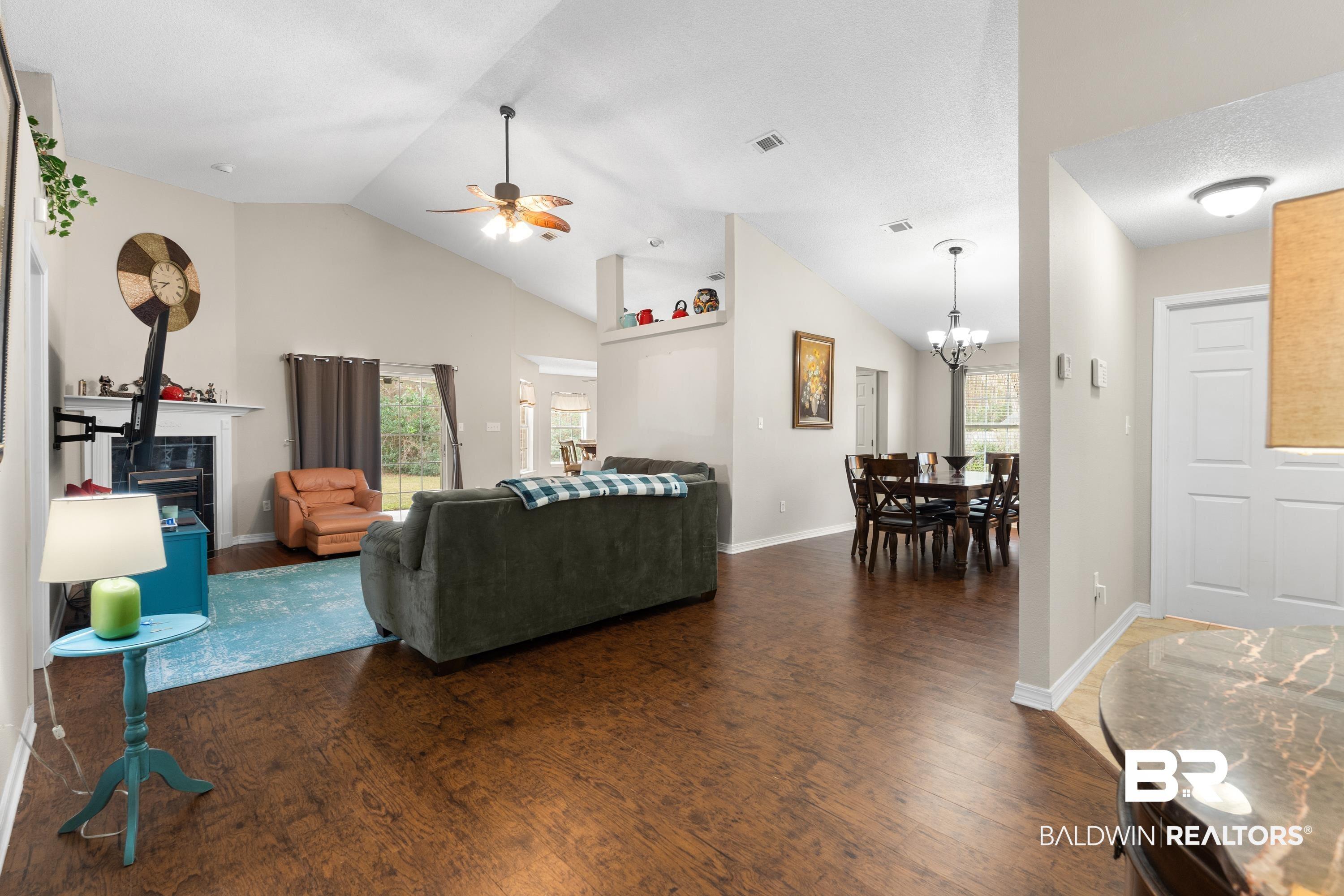Image 3: Living area featuring wood finished floors, high vaulted ceiling, and a ceiling fan