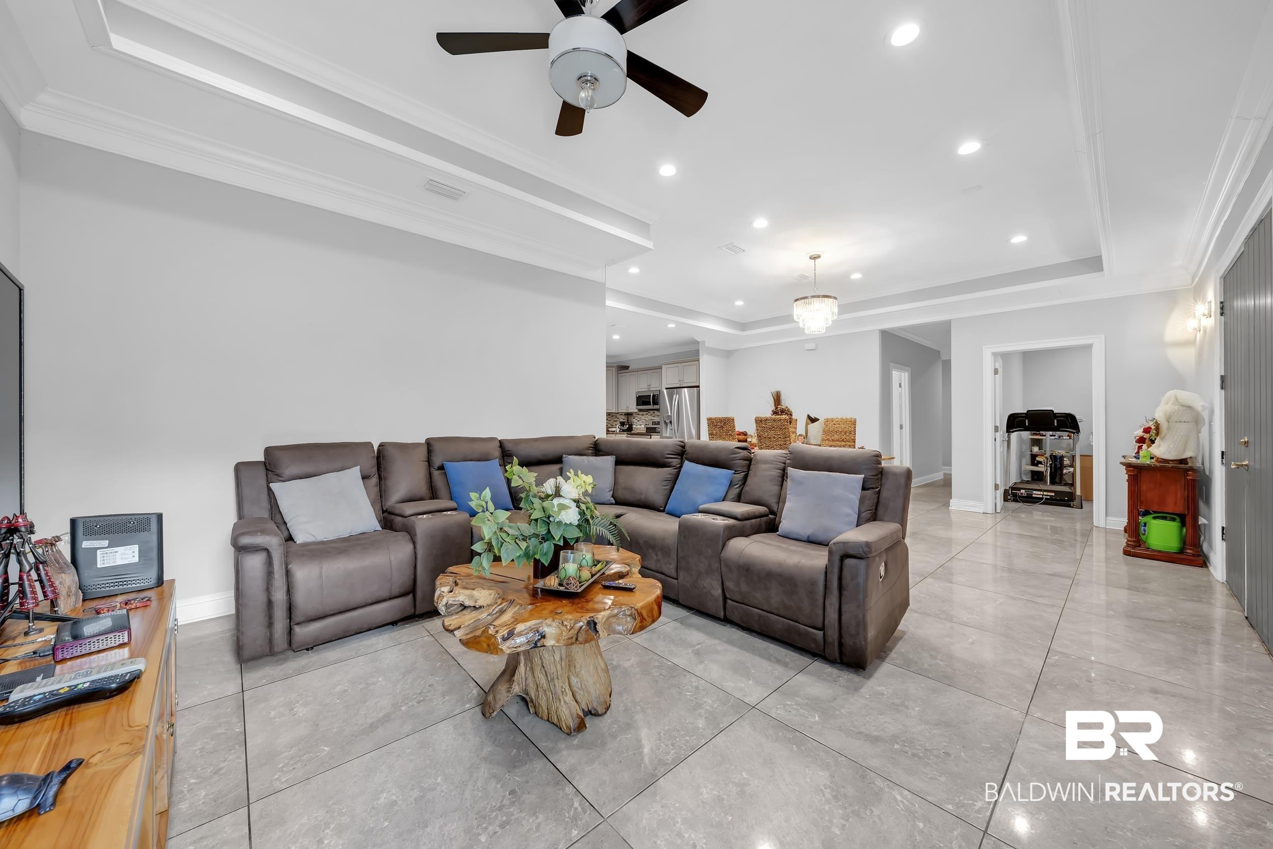 Image 2: Living room featuring a raised ceiling, recessed lighting, ceiling fan, and ornamental molding