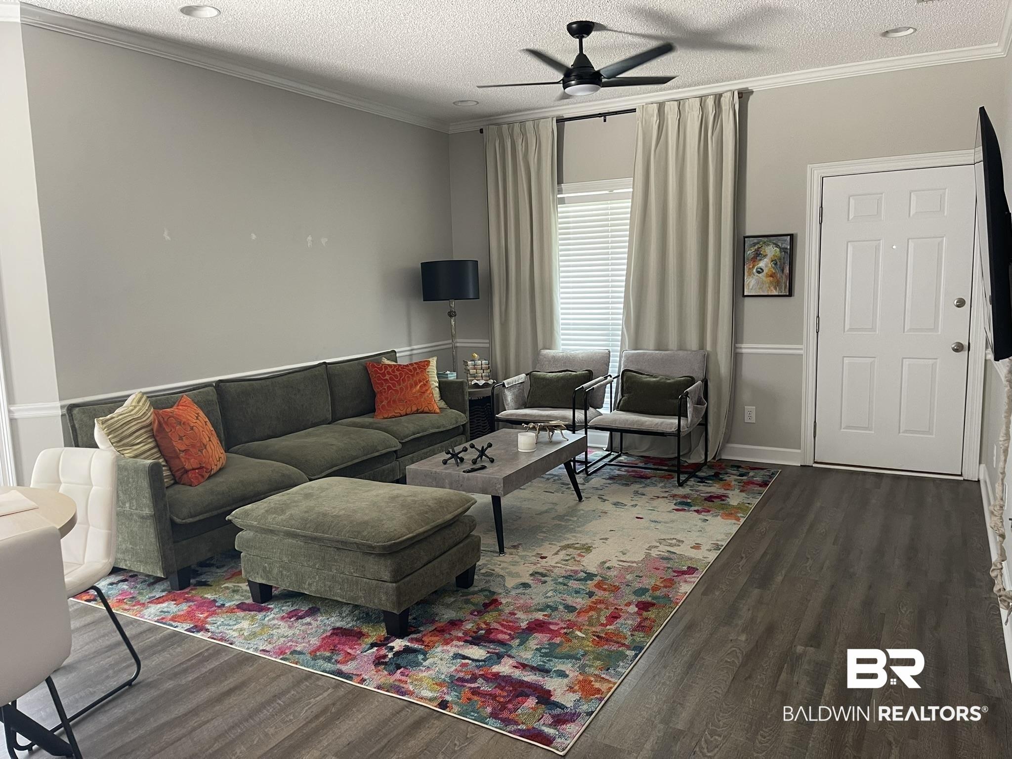Image 2: Open concept living area featuring wood-finish flooring, recessed lighting, crown molding, and a ceiling fan