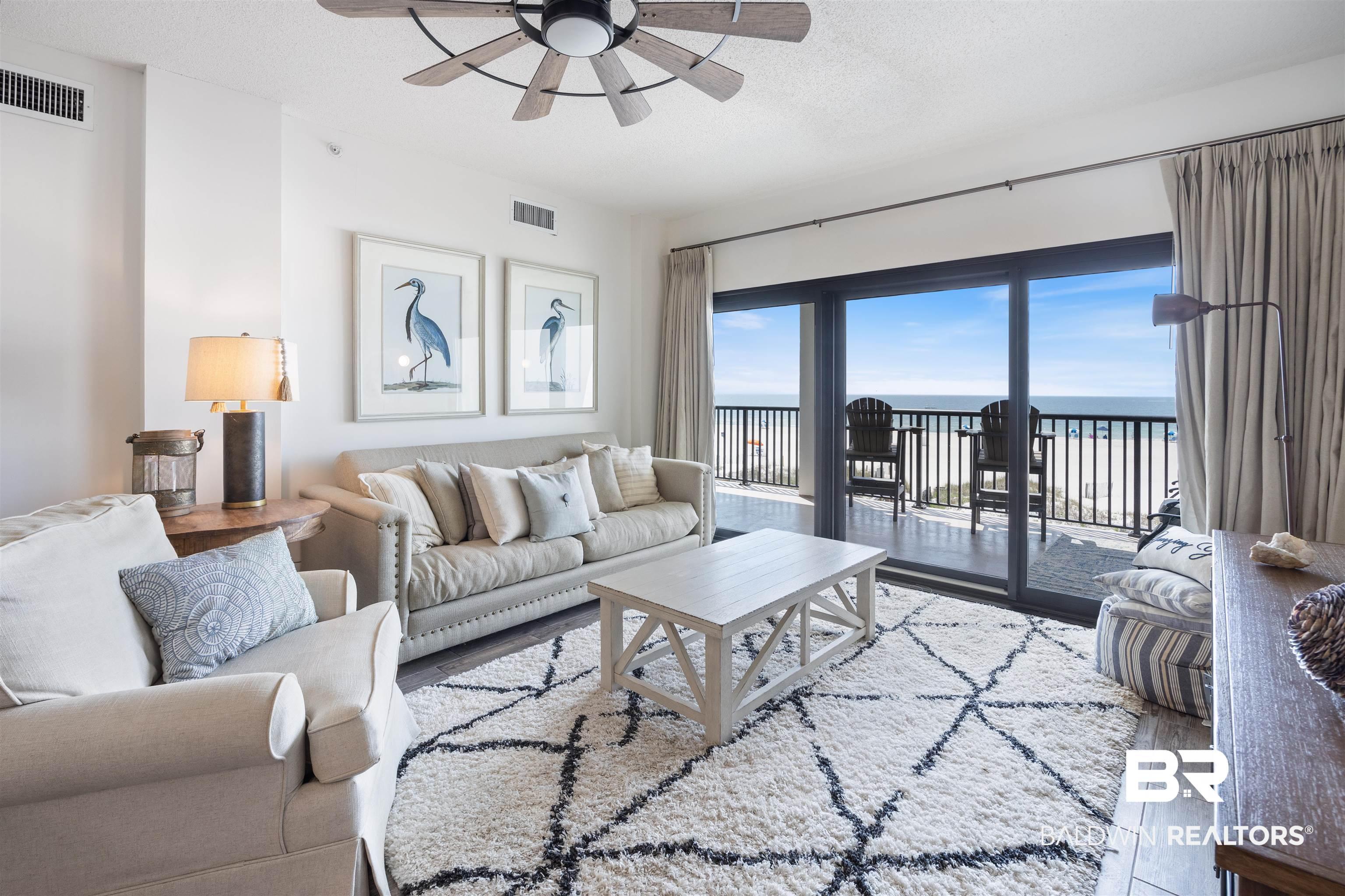 Image 3: Living area featuring wood-finish flooring, a ceiling fan with light fixture, and floor-to-ceiling glass doors opening to a private balcony