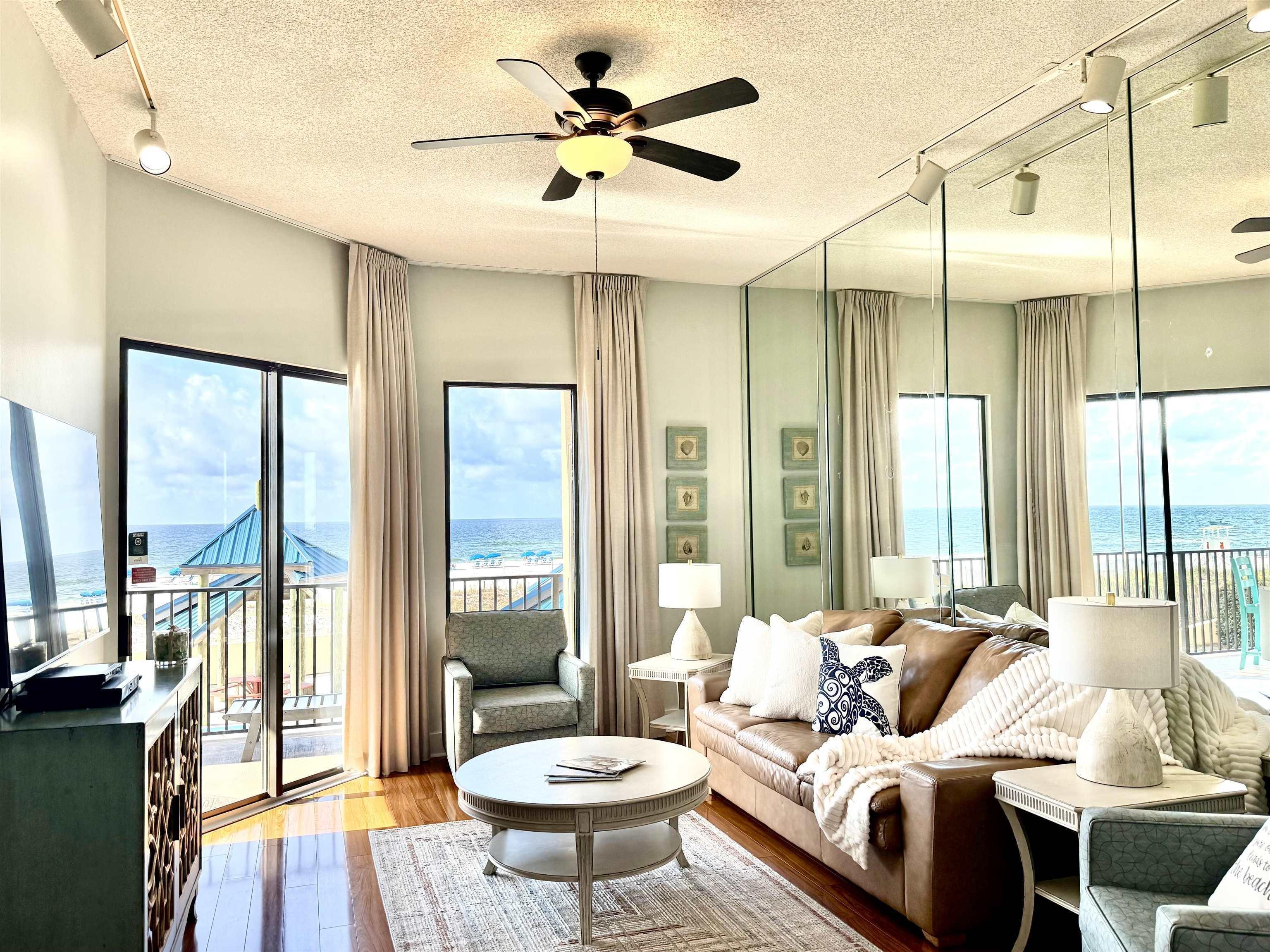 Image 3: Living area featuring a ceiling fan, a water view, wood finished floors, and a textured ceiling
