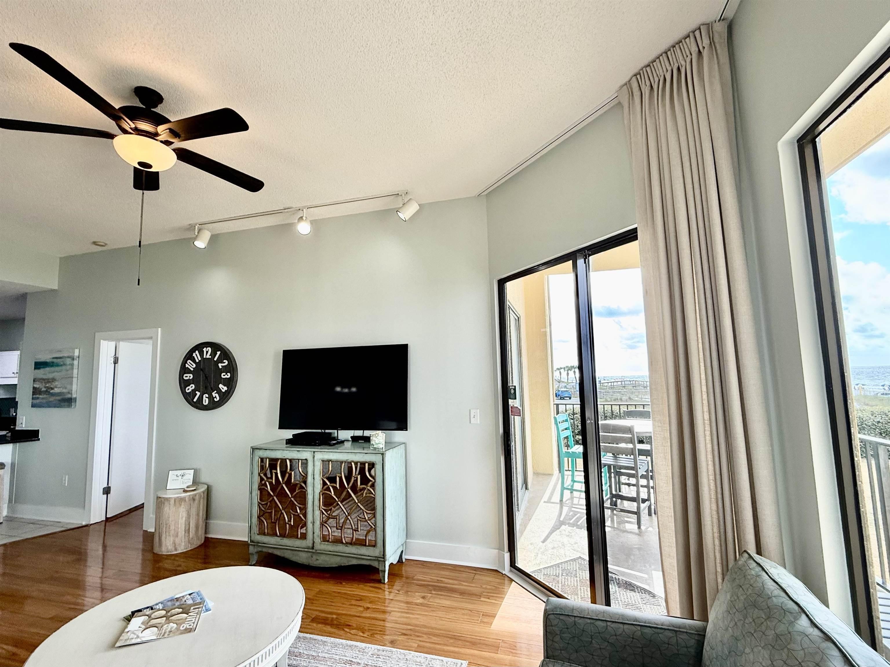 Image 4: Living room with track lighting, wood finished floors, a ceiling fan, and a textured ceiling