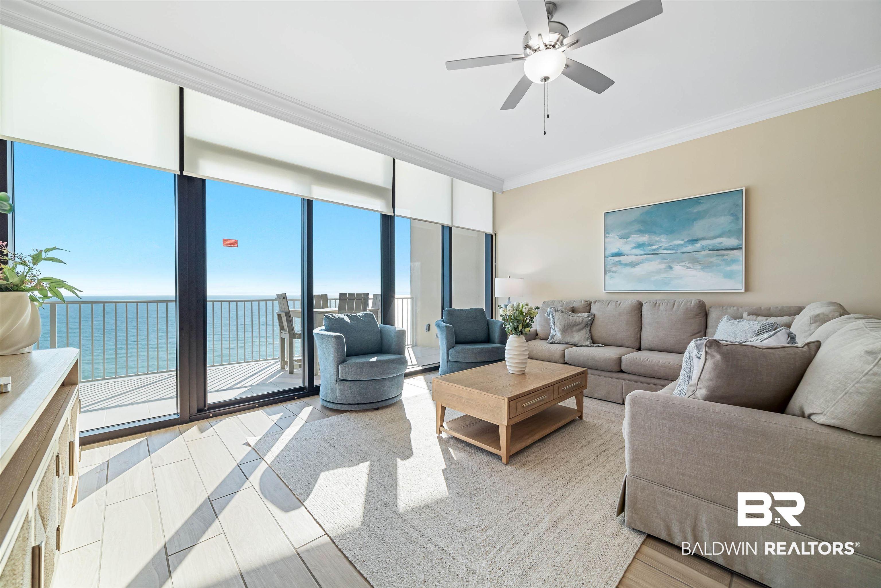 Image 2: Living area with a water view, crown molding, a wall of windows, and a ceiling fan