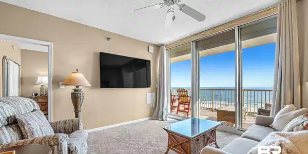 Image 4: Living area featuring a ceiling fan, a textured ceiling, carpet, a wall of windows, and baseboards