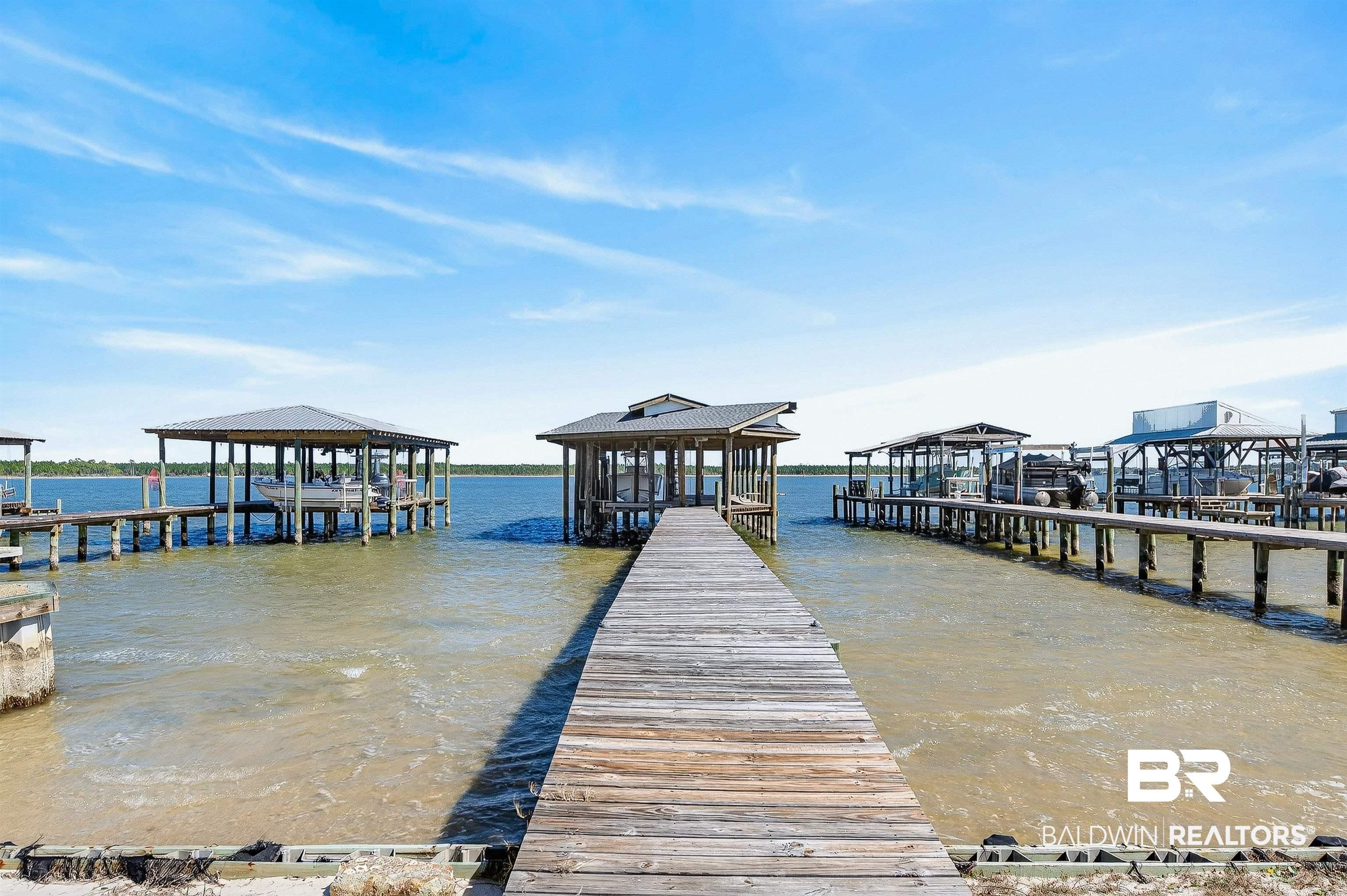 Image 1: Dock with boat lift, a water view, and a residential view