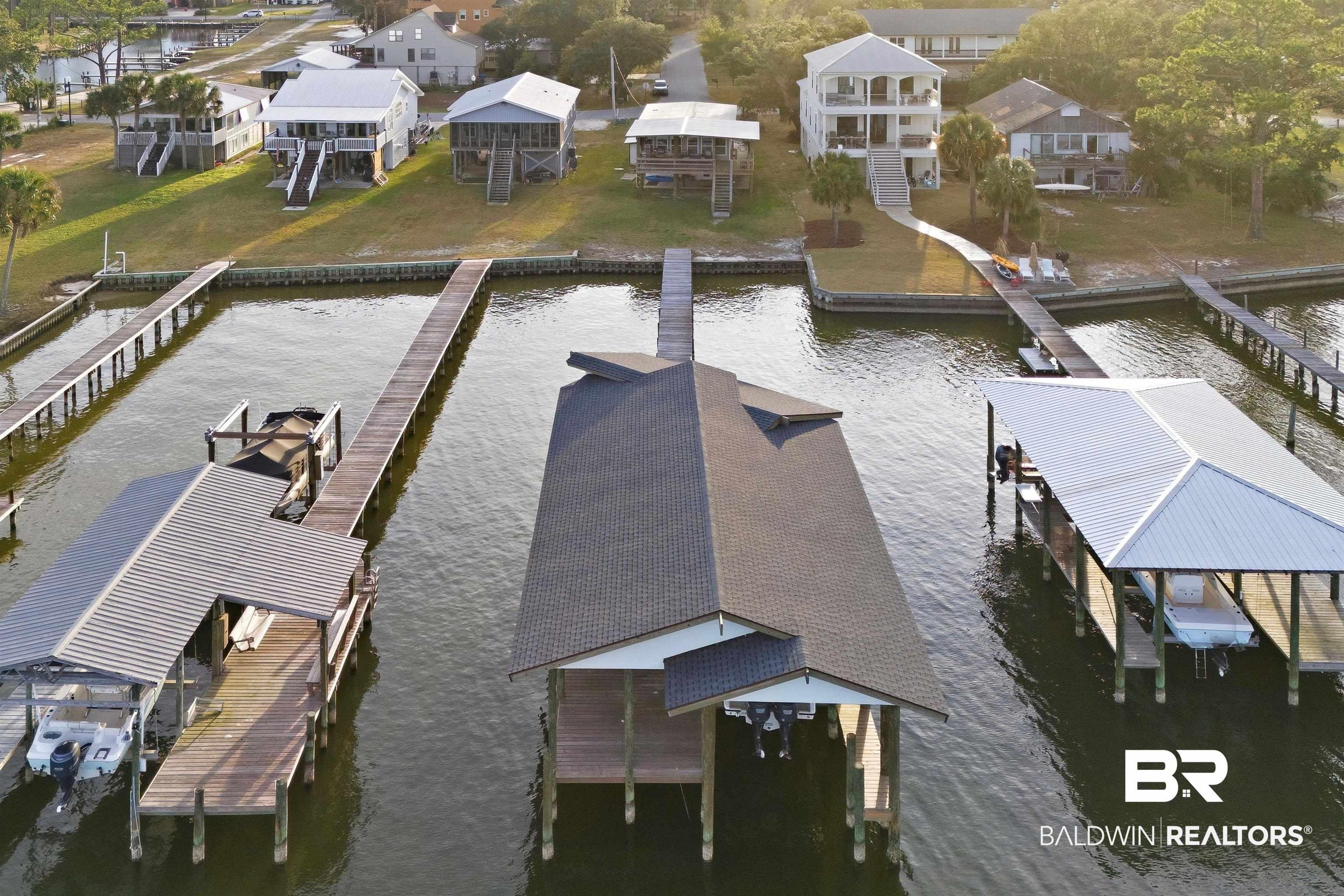 Image 2: Dock area featuring a water view, boat lift, and a residential view