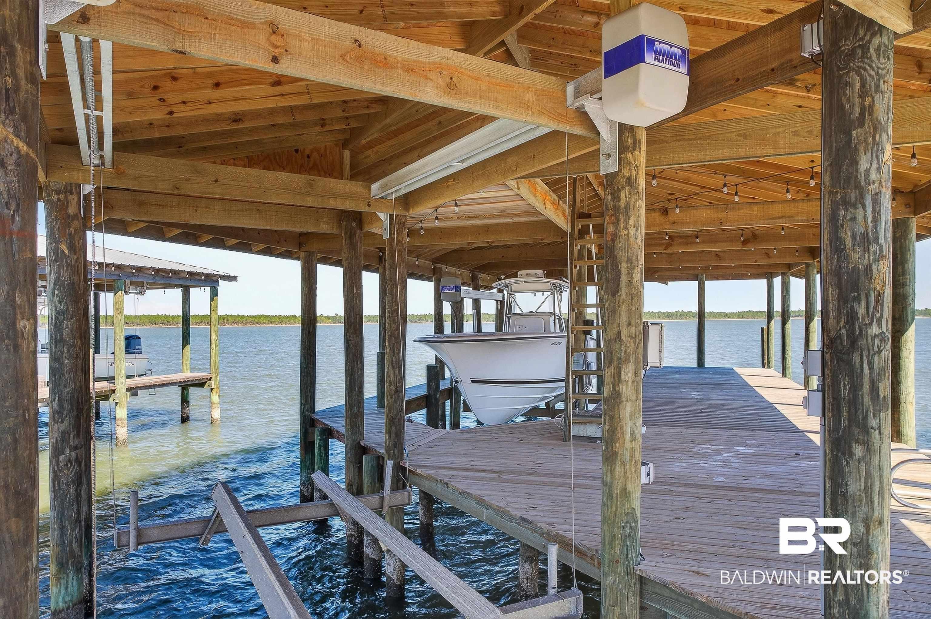 Image 4: Dock featuring boat lift and a water view