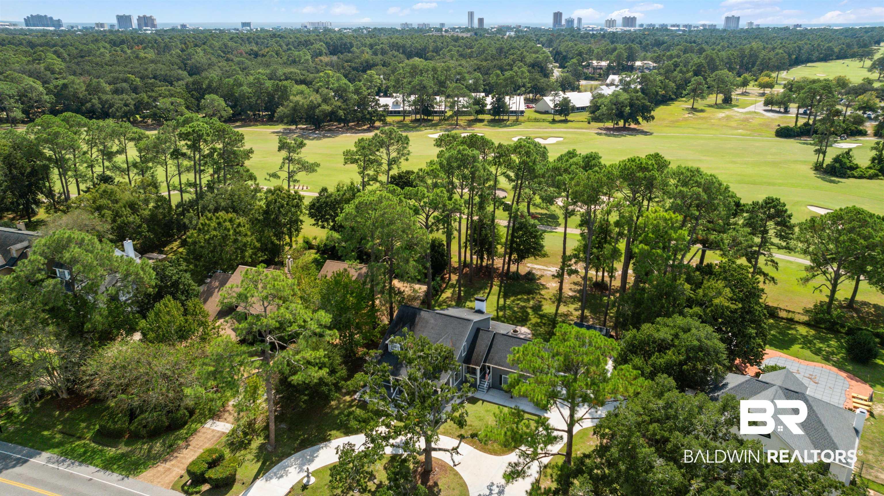 Image 3: Aerial perspective of suburban area with city skyline and a local golf course