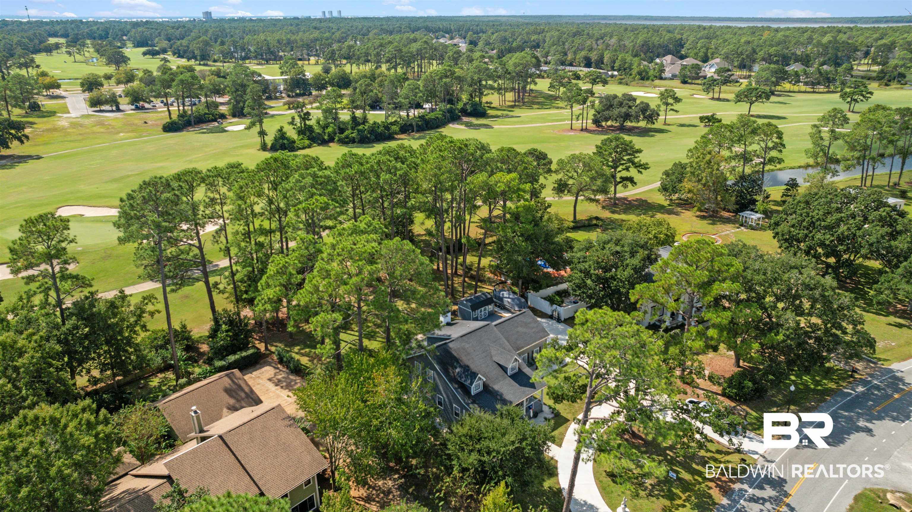Image 4: Aerial view of residential area with a golf course and a large body of water