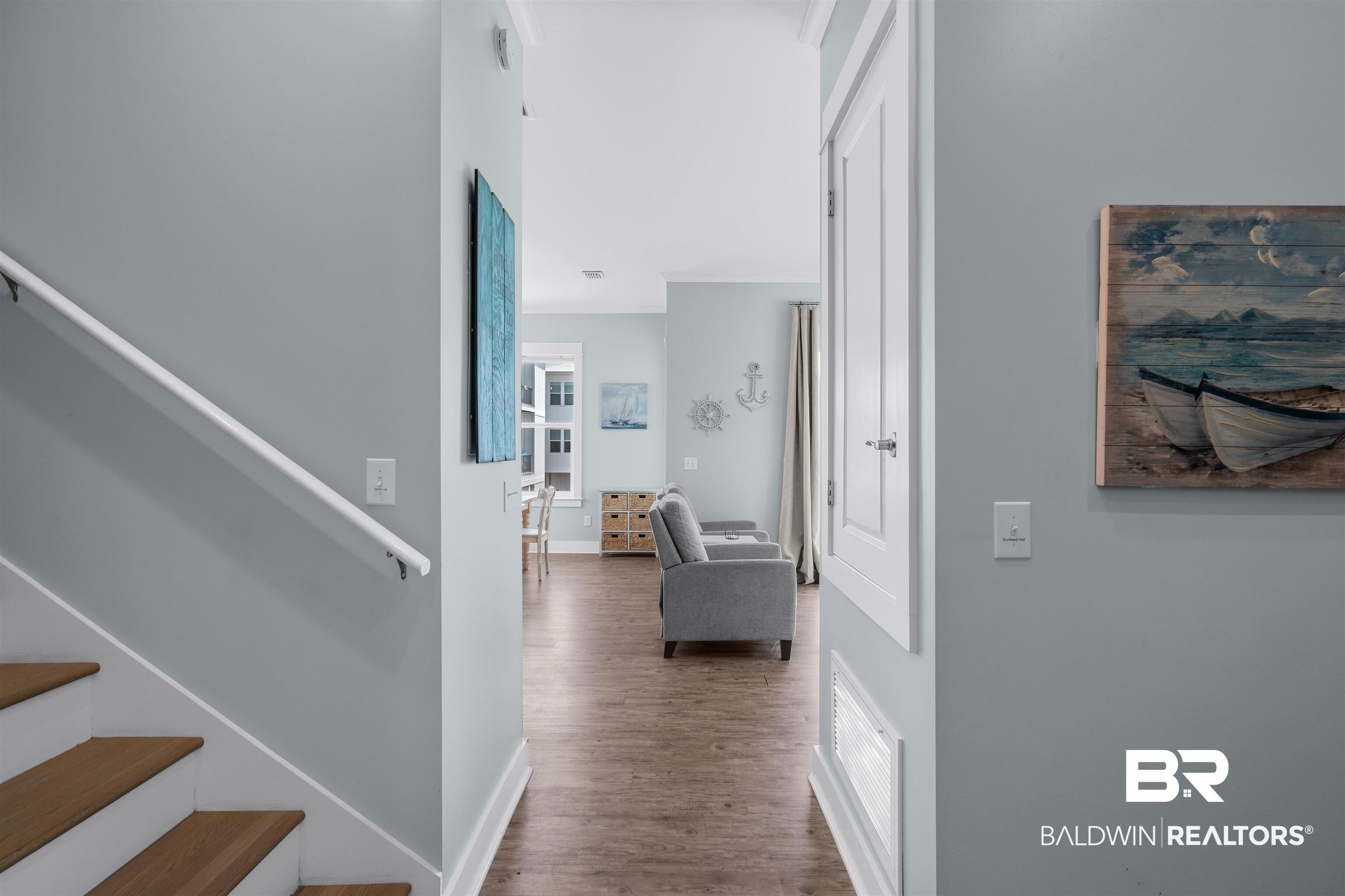 Image 3: Entryway featuring wood-finish flooring, white baseboards, and a white staircase with wood treads