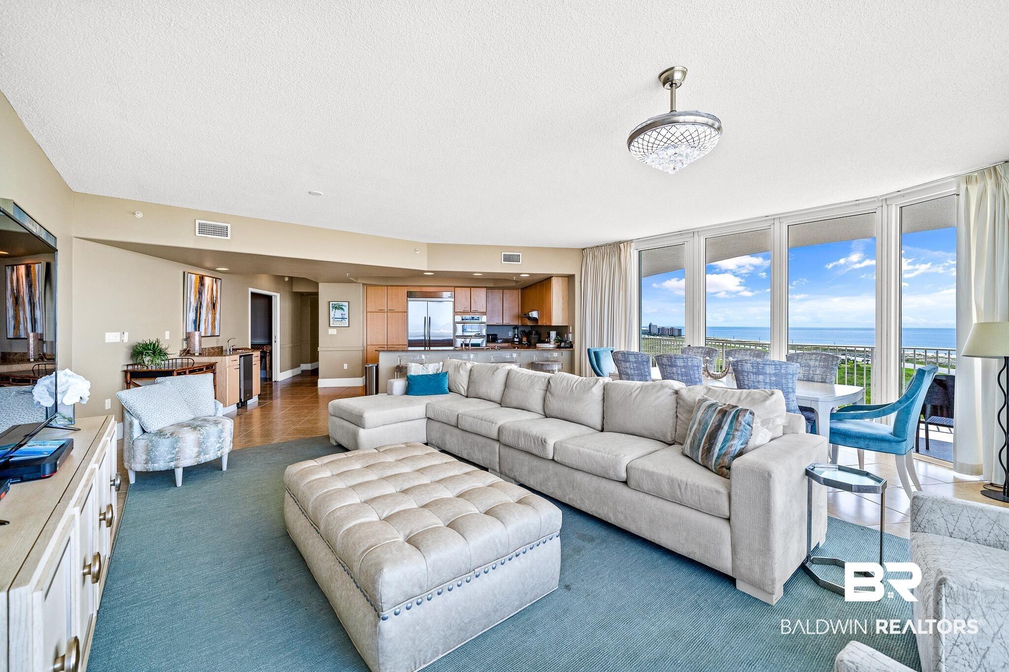 Image 4: Living area featuring carpet floors, visible vents, a water view, and a textured ceiling