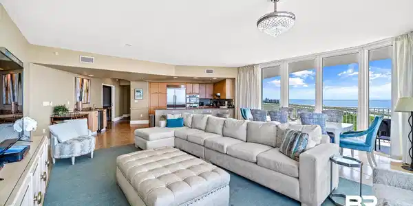 Image 4: Living area featuring carpet floors, visible vents, a water view, and a textured ceiling