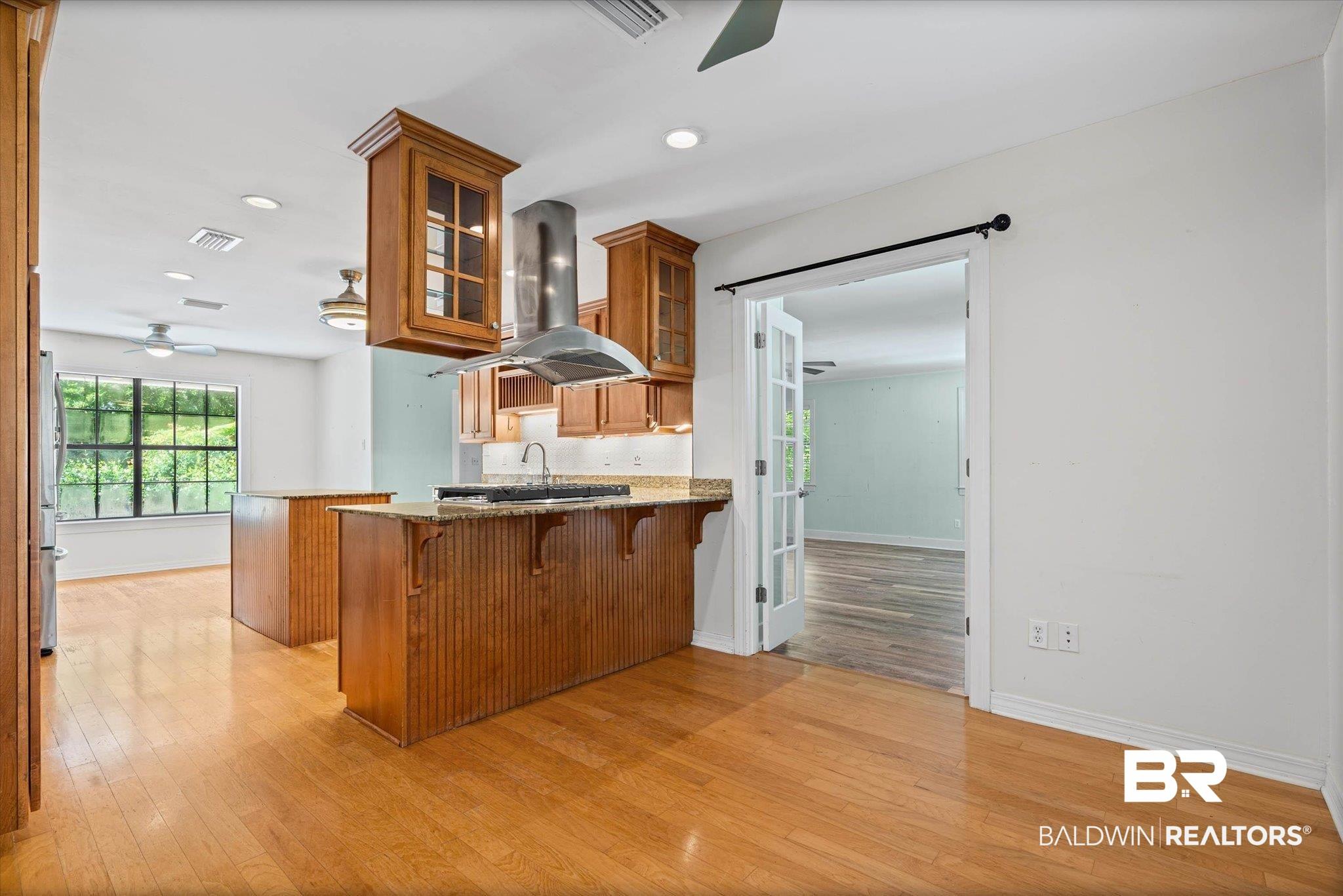 Image 4: Additional view of kitchen featuring breakfast nook & additional dining area, on either end of kitchen. View of entry to Living Room.
