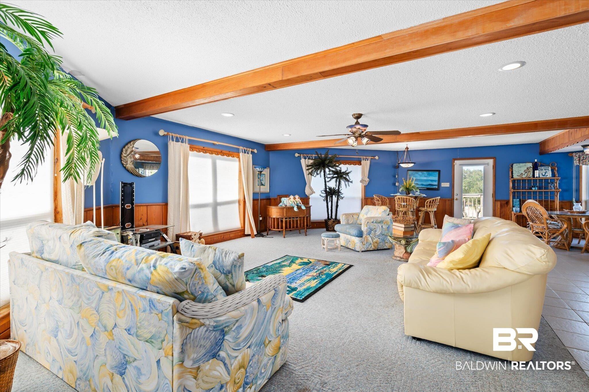 Image 4: Carpeted living room with beam ceiling, a textured ceiling, and ceiling fan