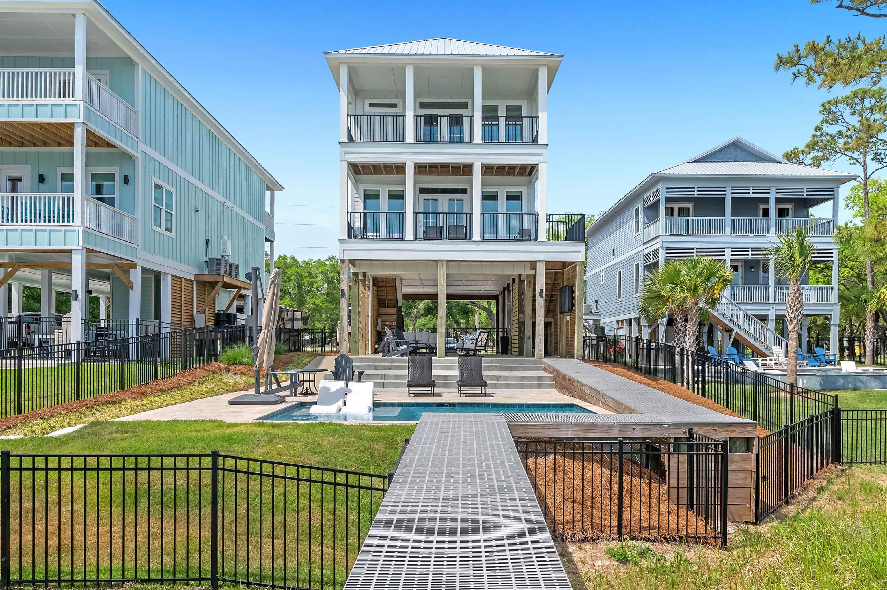 Image 1: Back of property featuring fence private yard, a balcony, a patio, a fenced in pool, and a yard