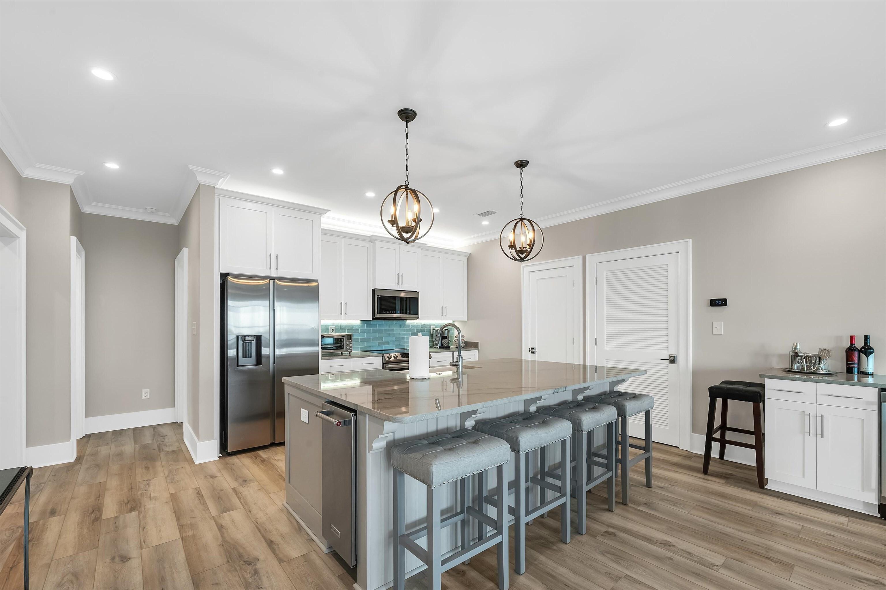 Image 2: Kitchen featuring crown molding, a kitchen breakfast bar, a sink, backsplash, and stainless steel appliances