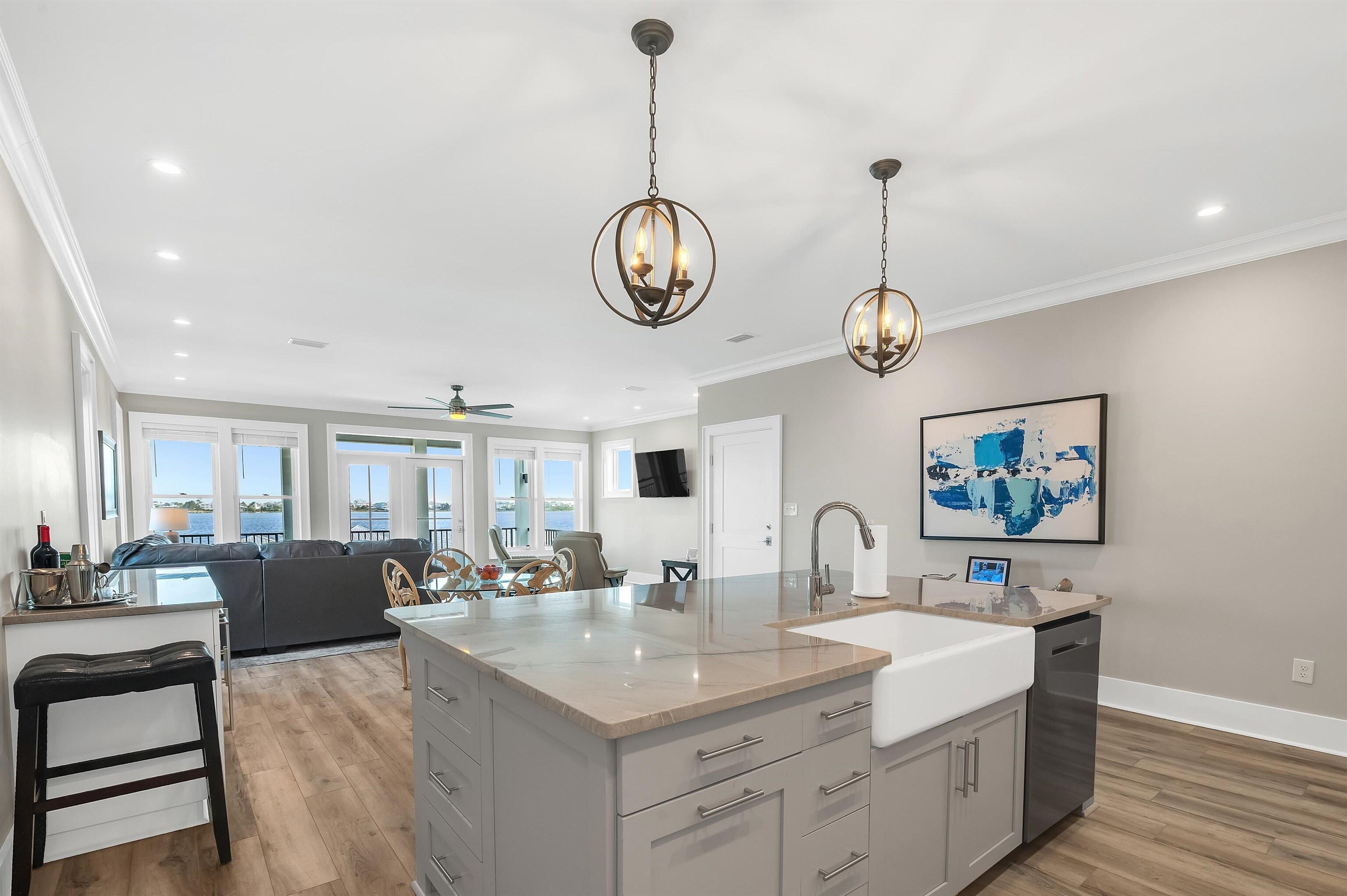 Image 4: Kitchen with crown molding, a sink, dishwasher, a kitchen island with sink, and ceiling fan with notable chandelier