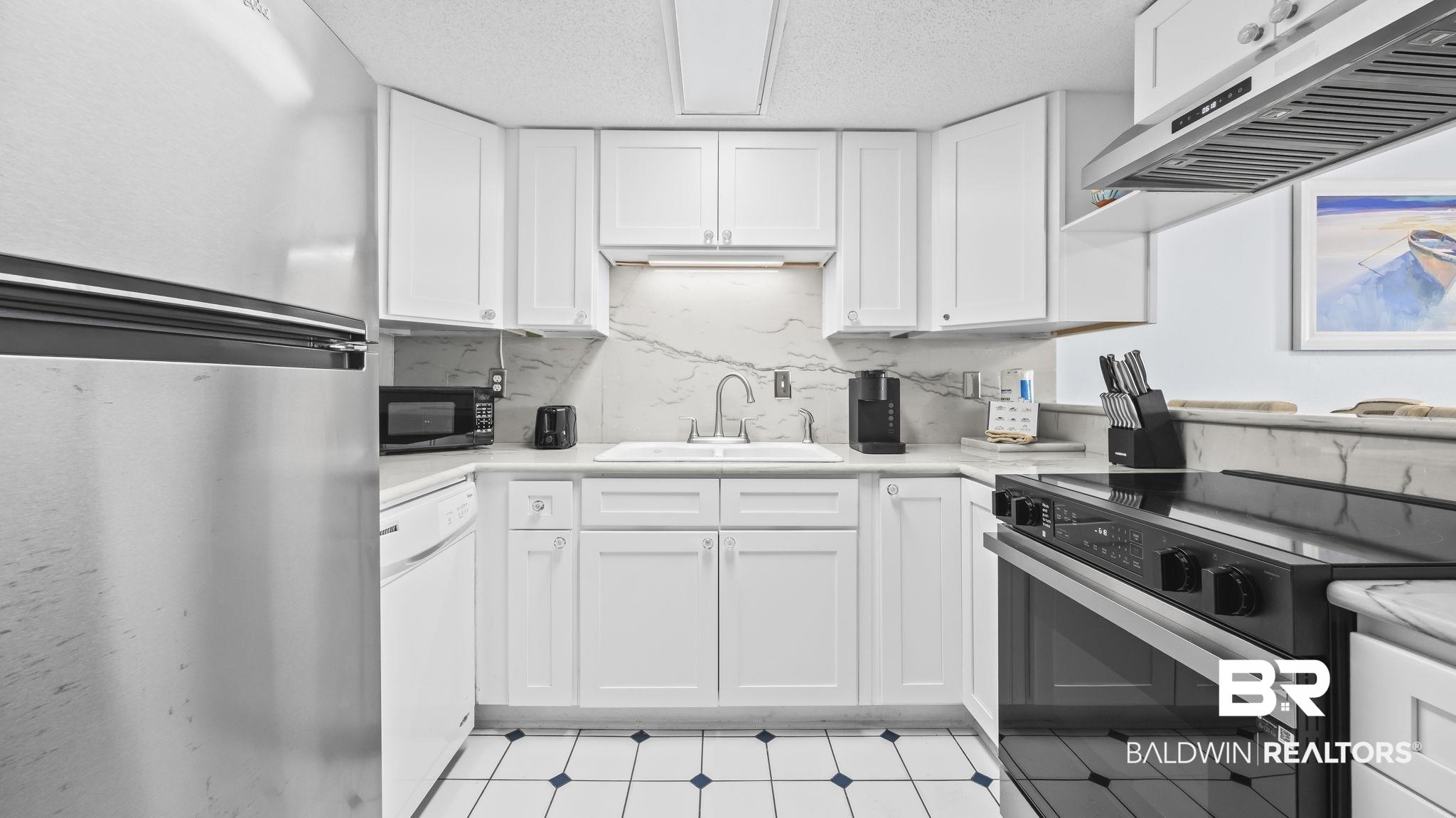 Image 3: Kitchen with black appliances, extractor fan, white cabinets, a textured ceiling, and light floors