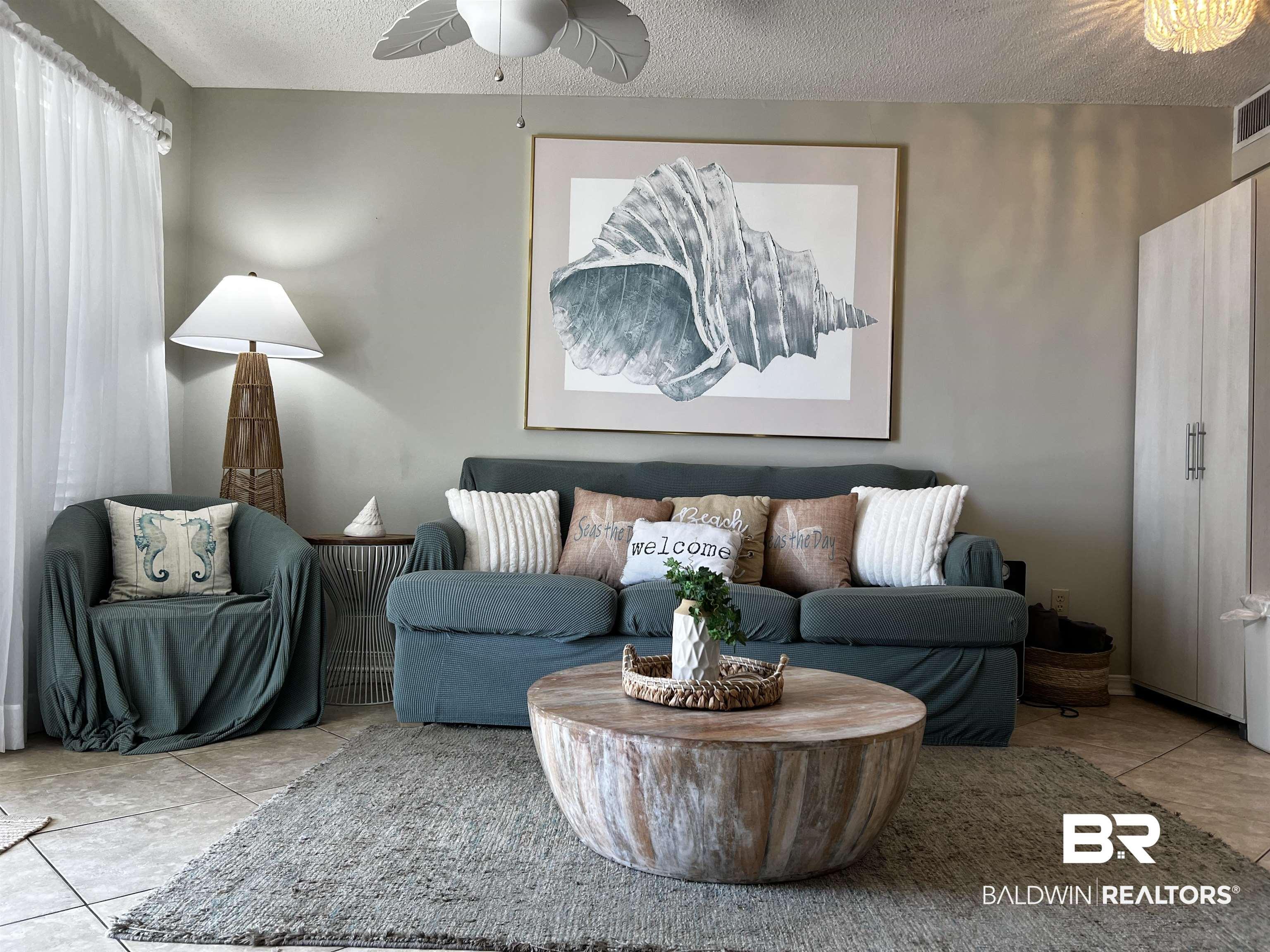 Image 4: Living area featuring tile patterned floors, a textured ceiling, and ceiling fan