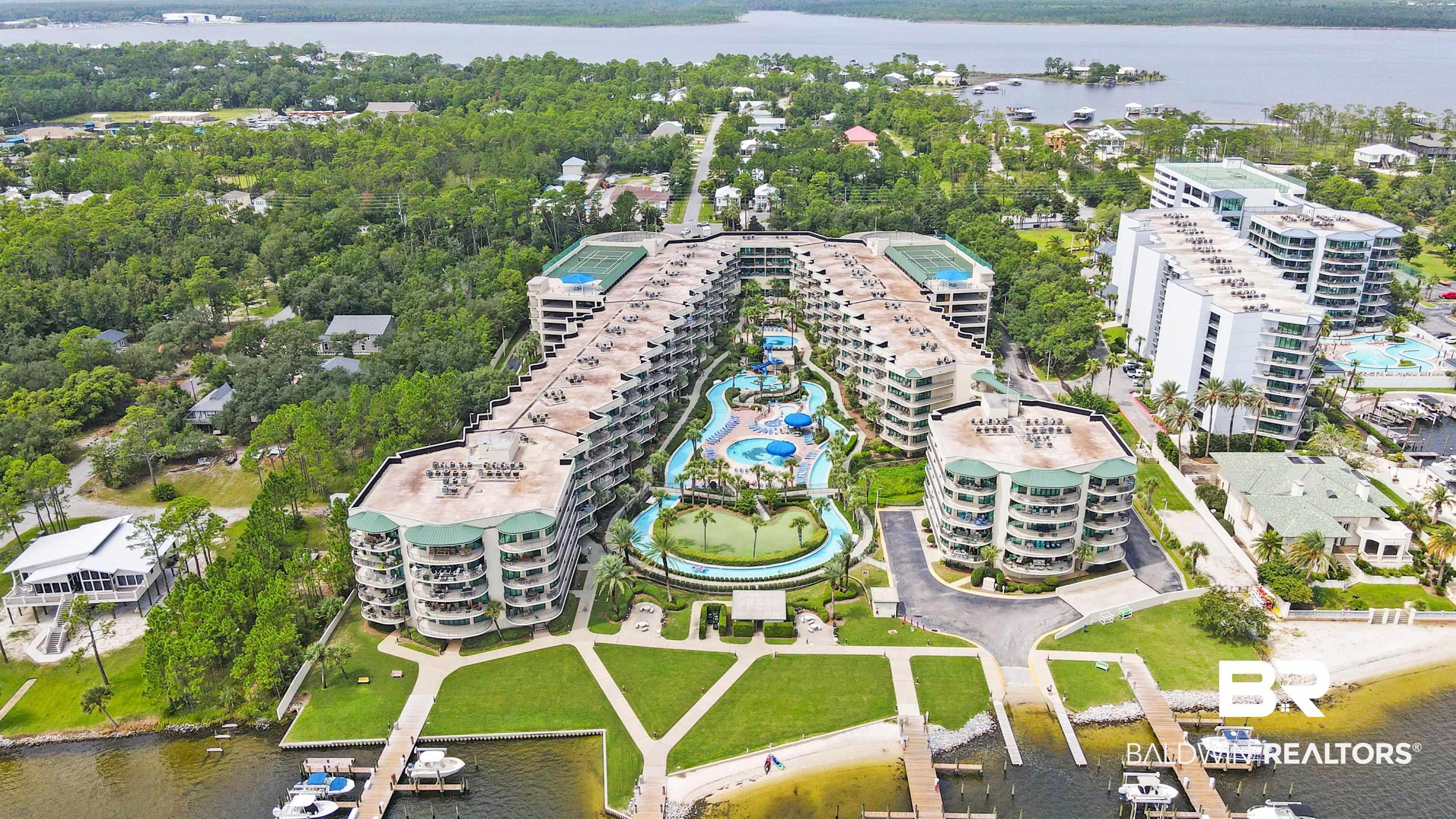 Image 3: Extensive resort-style property featuring multiple buildings, lush green landscaping, and a large central water park with slides and multiple pools