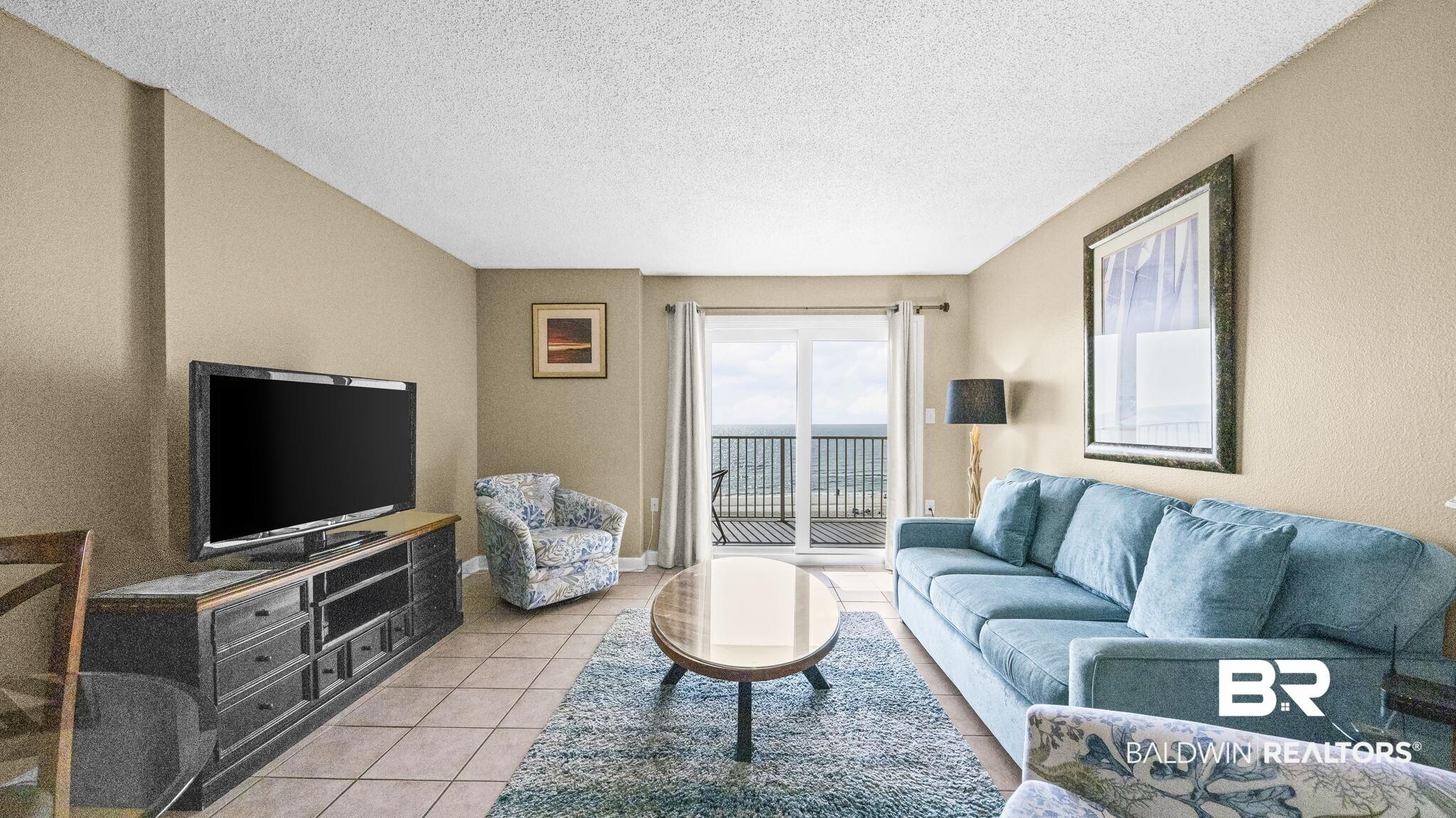 Image 2: Living room with light tile patterned floors and a textured ceiling