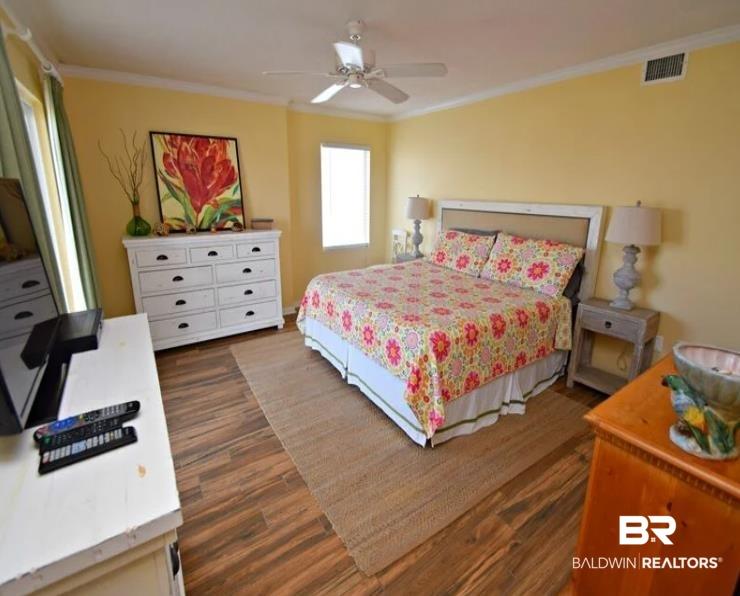 Image 3: Bedroom with dark wood-style flooring, crown molding, and a ceiling fan
