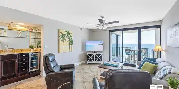 Image 2: Living room with beverage cooler, bar, and ceiling fan
