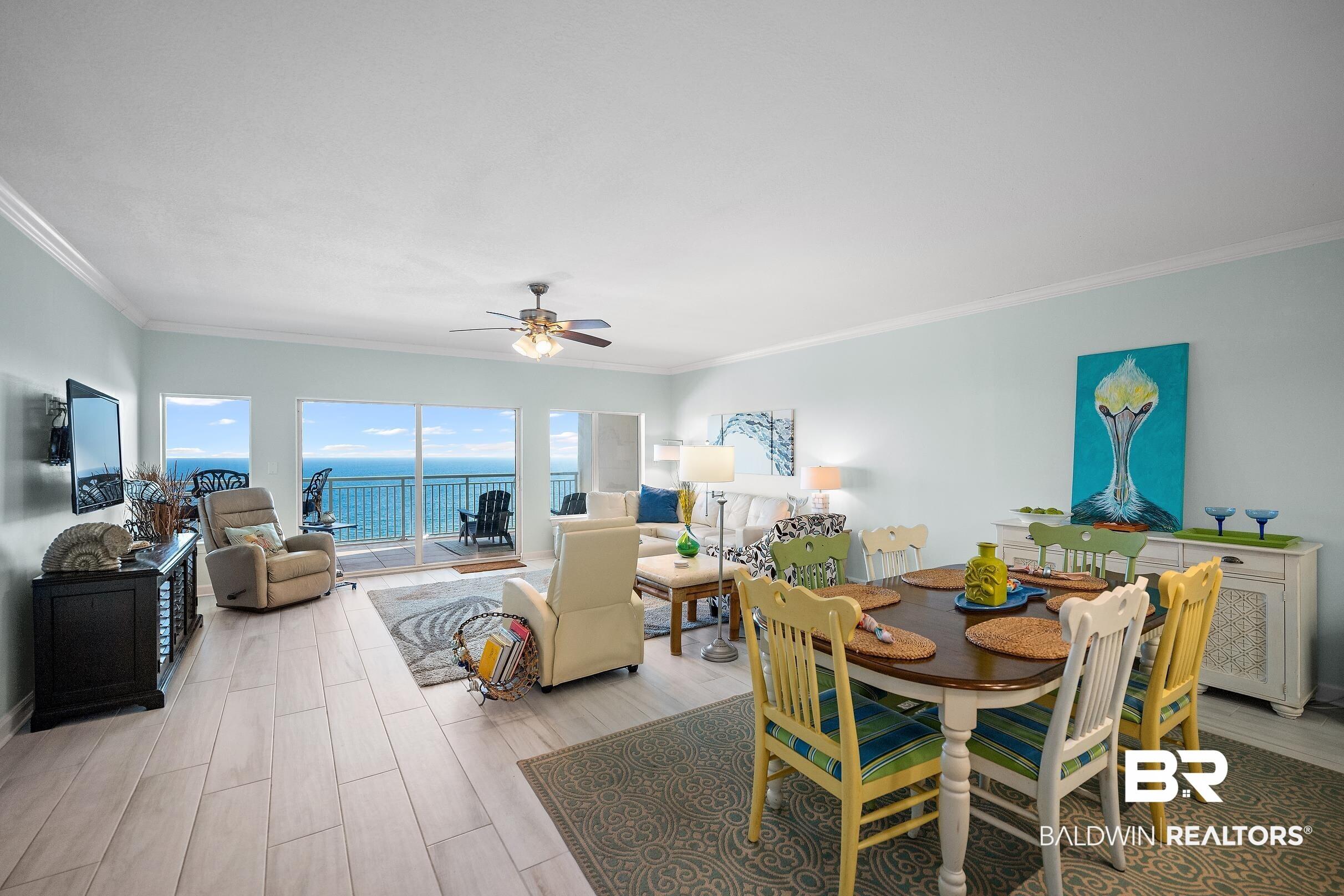 Image 4: Dining space with wood tiled floors, ceiling fan, and ornamental molding
