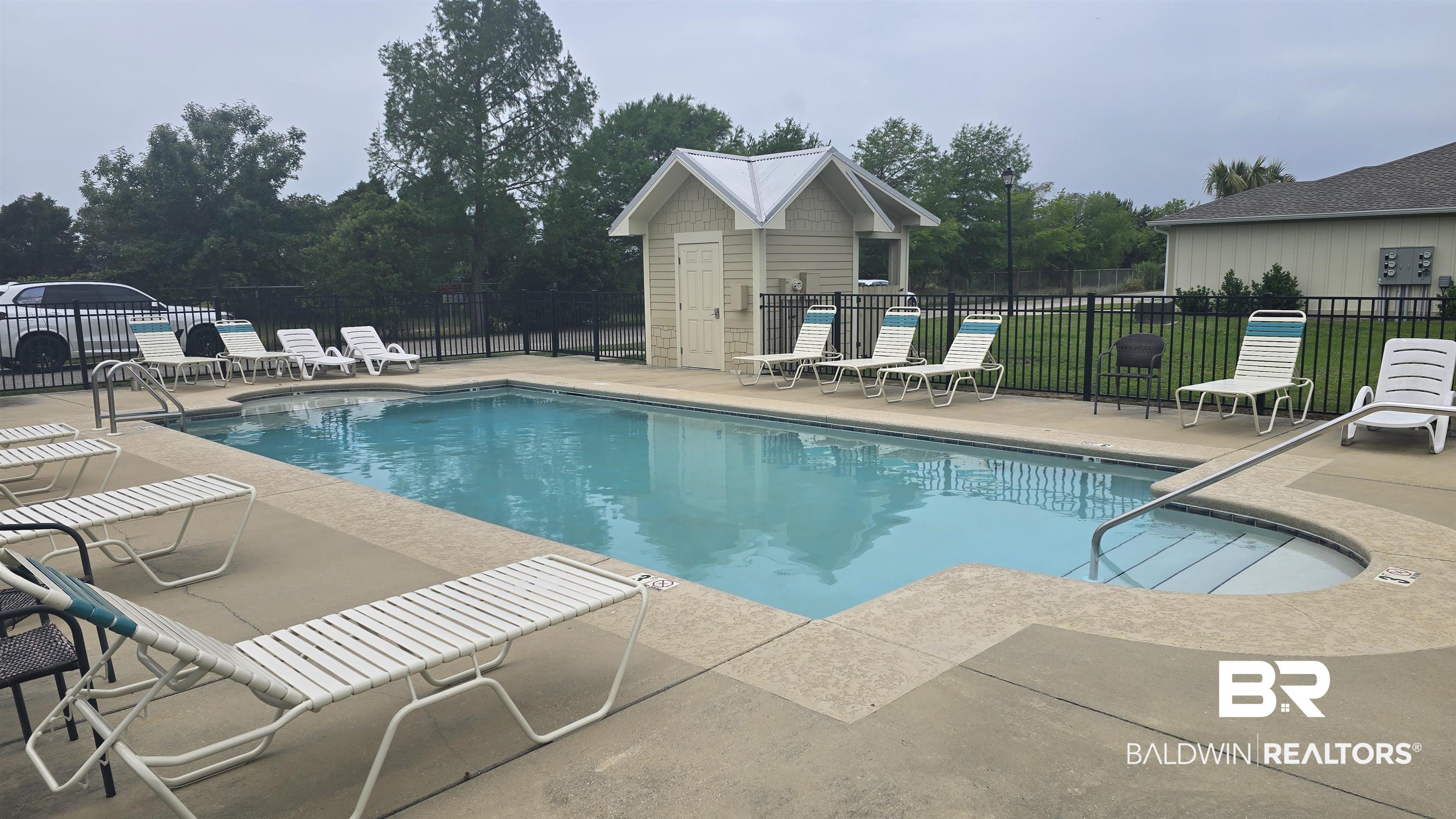 Image 3: Rectangular swimming pool with an integrated spa, surrounded by a concrete deck