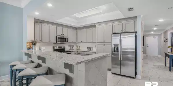 Image 3: Kitchen featuring light gray cabinetry, stainless steel appliances, a white subway tile backsplash, and granite countertops