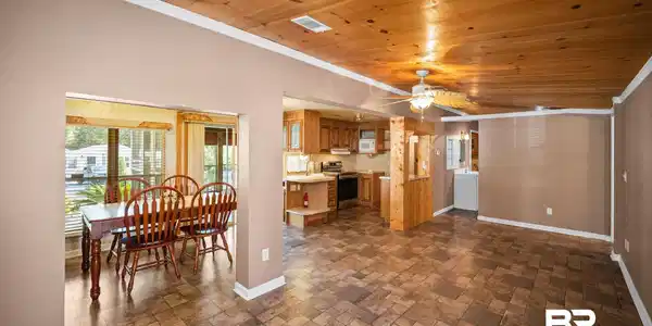 Image 3: Open concept living, kitchen, and dining with wood ceiling, wood plank flooring, and ceiling fan