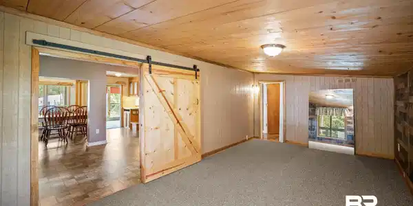 Image 4: Bedroom featuring a barn door, wood ceiling, and carpet floors