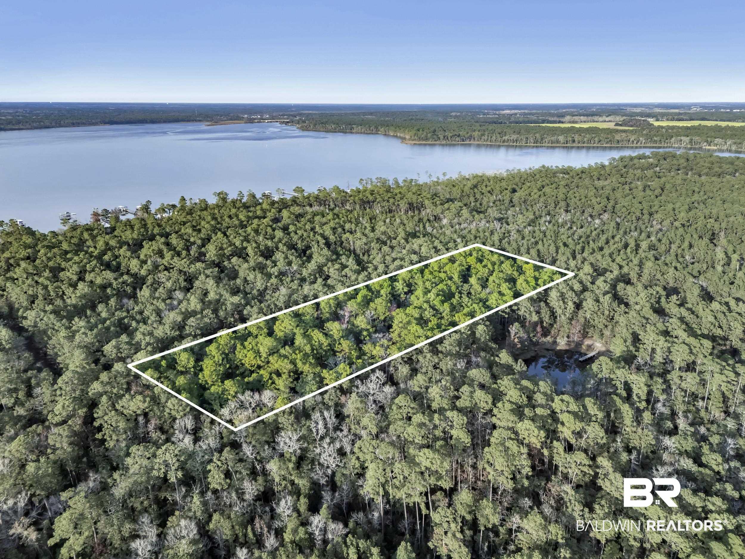 Image 2: Aerial view of property's location with a large body of water and property parcel outlined