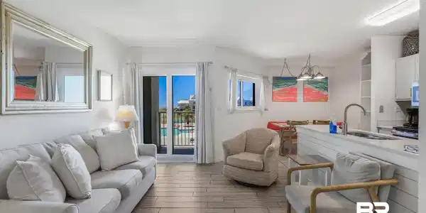 Image 2: Open concept living area featuring wood-finish flooring