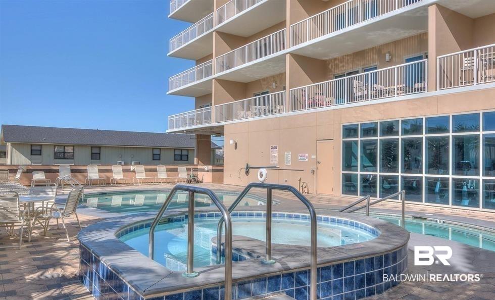Image 4: Community pool featuring a patio area and a hot tub