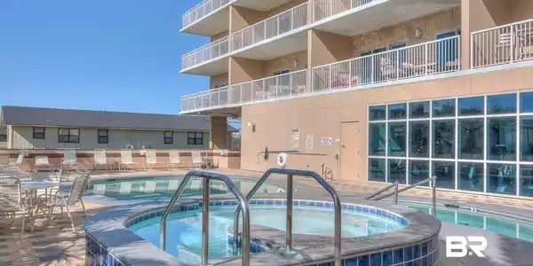 Image 4: Community pool featuring a patio area and a hot tub
