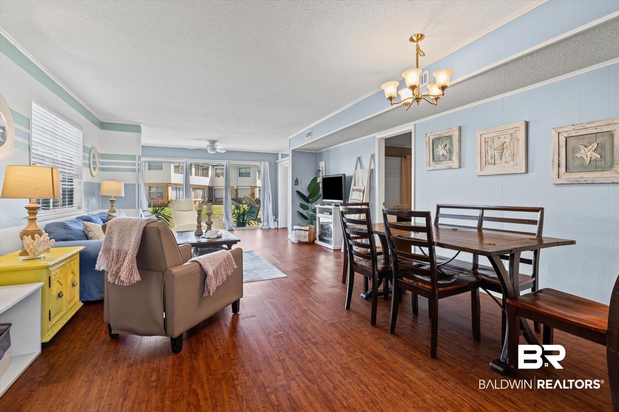 Image 3: Open-concept living and dining area featuring wood-finish flooring throughout