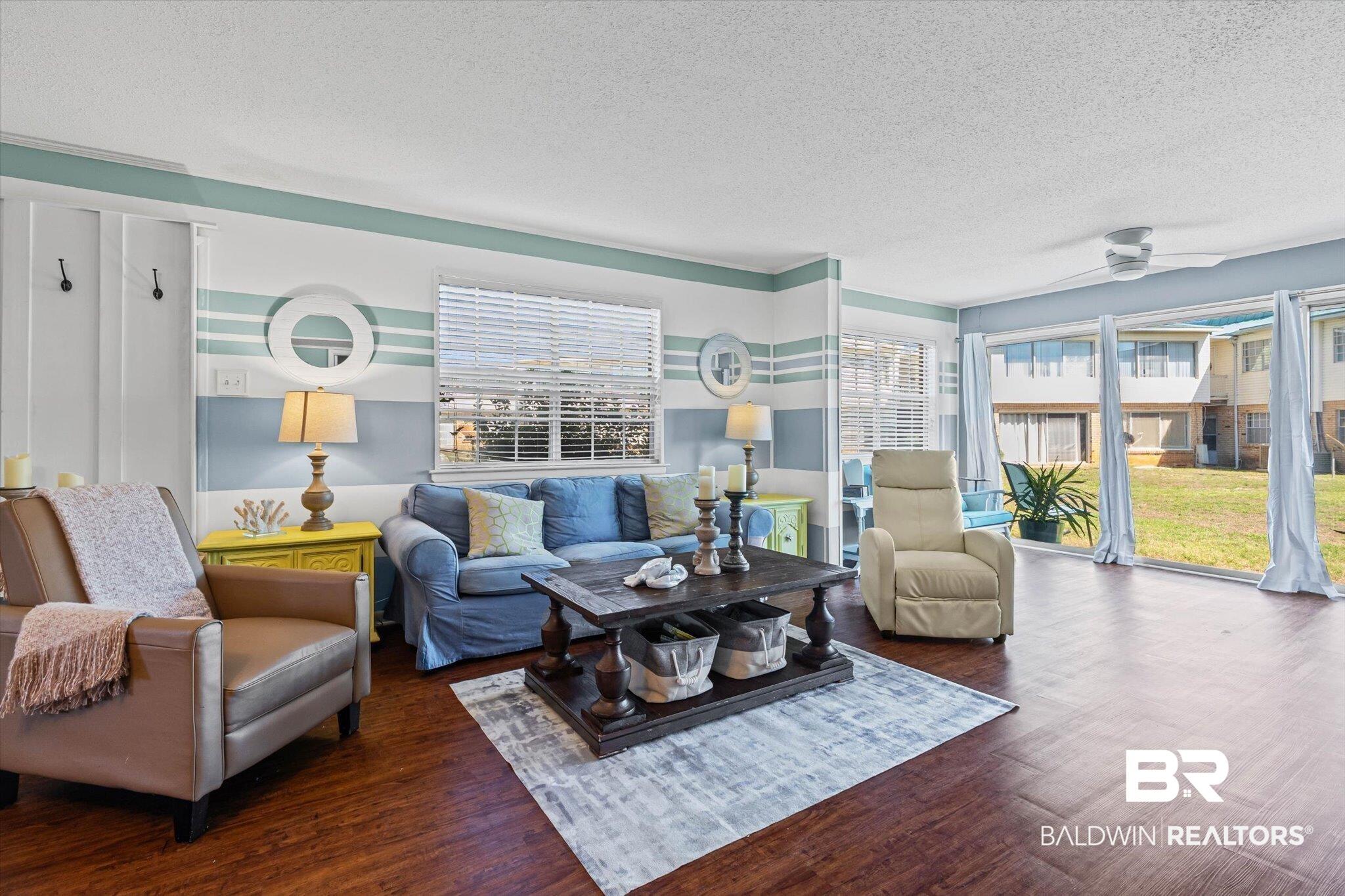 Image 4: Living area featuring wood-finish flooring, a ceiling fan, and sliding glass doors