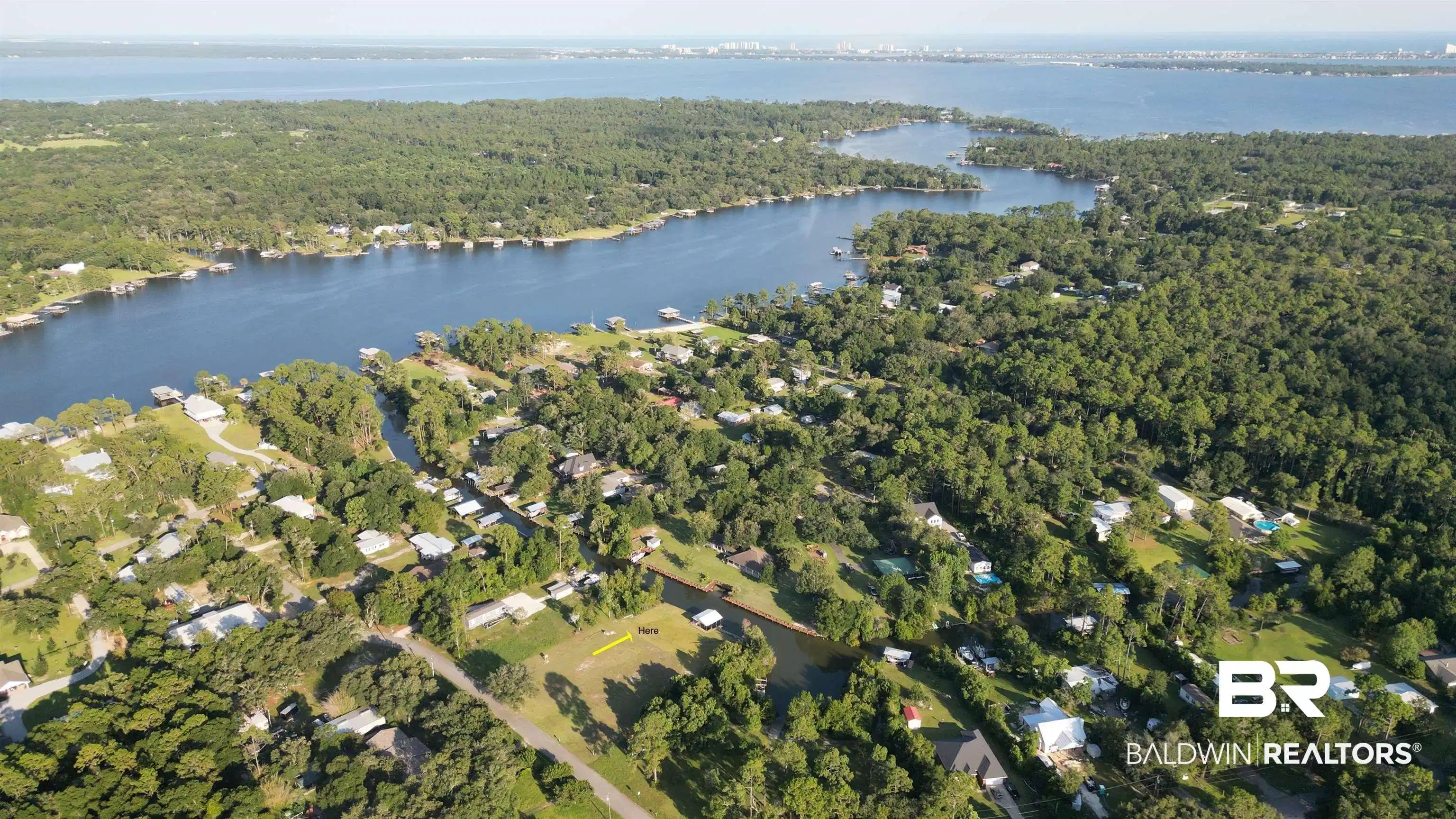 Image 1: Aerial view of property's location featuring a forest and a nearby body of water