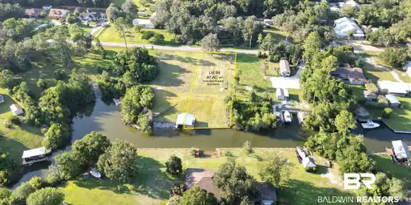 Image 2: Aerial view of property's location featuring property boundaries highlighted and a nearby body of water