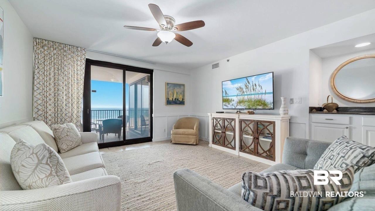 Image 2: Living room with ceiling fan and a wainscoted wall