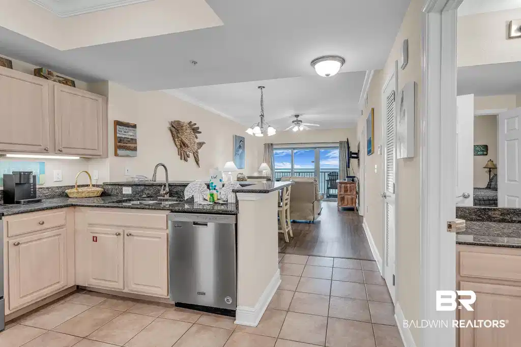 Image 1: Kitchen featuring crown molding, dark stone countertops, light wood finish cabinets, dishwasher, and open floor plan