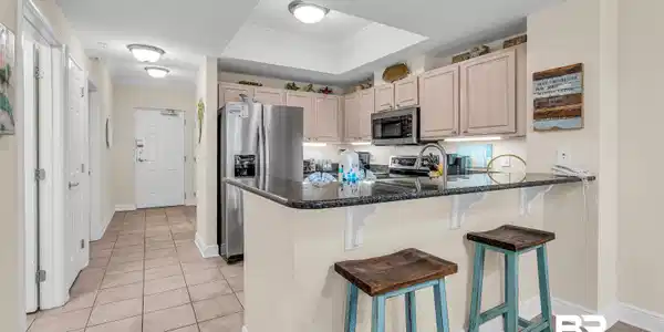 Image 4: Kitchen featuring a kitchen breakfast bar, crown molding, stainless steel appliances, a peninsula, and light tile patterned flooring