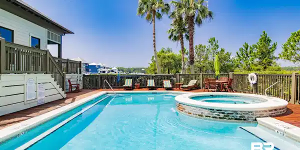 Image 4: Expansive outdoor pool area featuring a rectangular swimming pool, integrated circular spa with brick-finish surround, and a surrounding wood deck