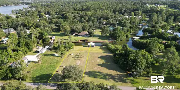 Image 3: Aerial view of property and surrounding area featuring a large body of water and property parcel outlined