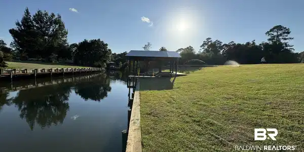 Image 4: Dock area featuring a yard and a water view