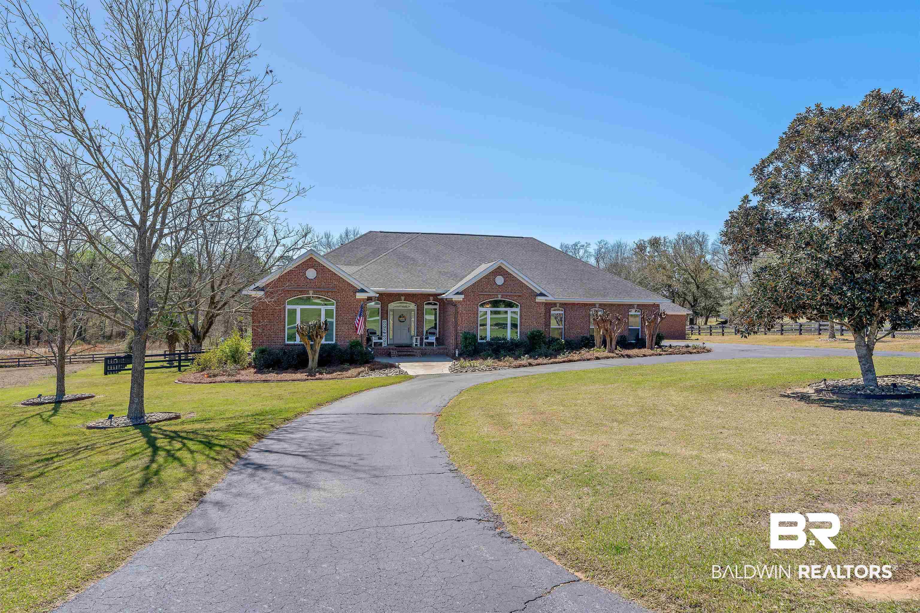 Image 2: View of front of property featuring brick siding, curved driveway, and a shingled roof